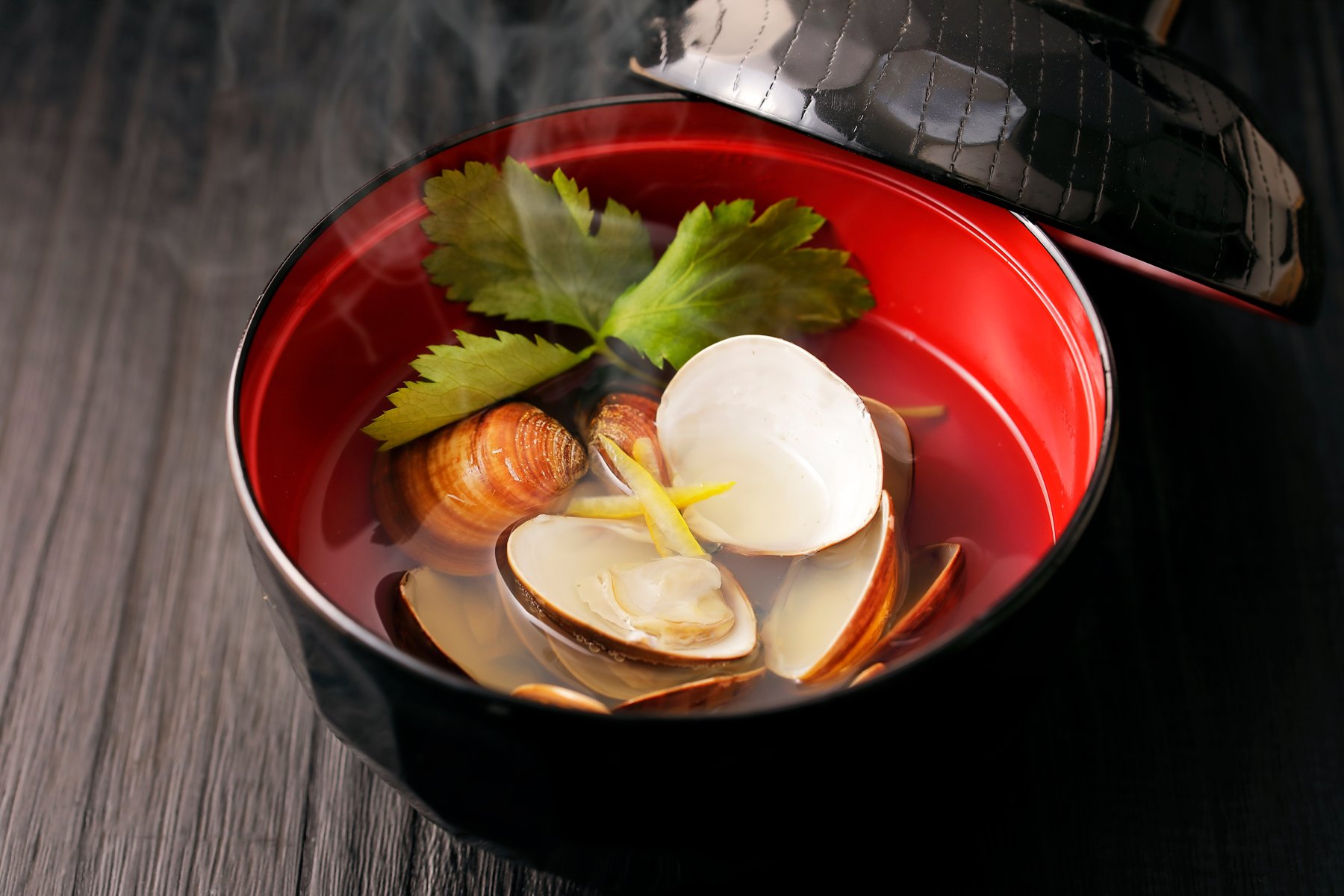 A flat lay of Japanese tableware: a lacquer tray, plates, cups, small bowls, and a chopstick rest with chopsticks